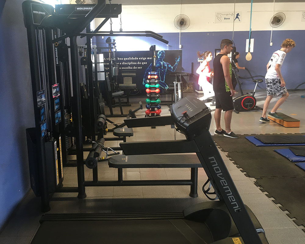 Foto interna exibindo equipamentos da academia e alunos